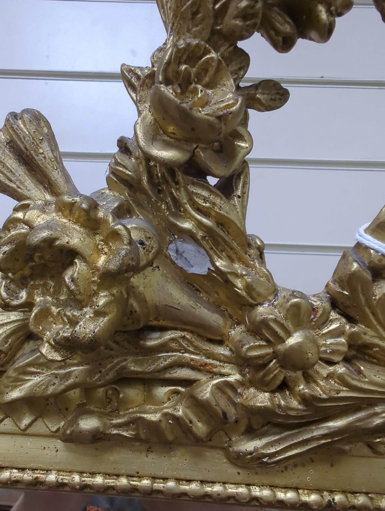 A late 19th century French Louis XVI style giltwood and composition overmantel mirror with floral swag pediment width 110cm, height 185cm.